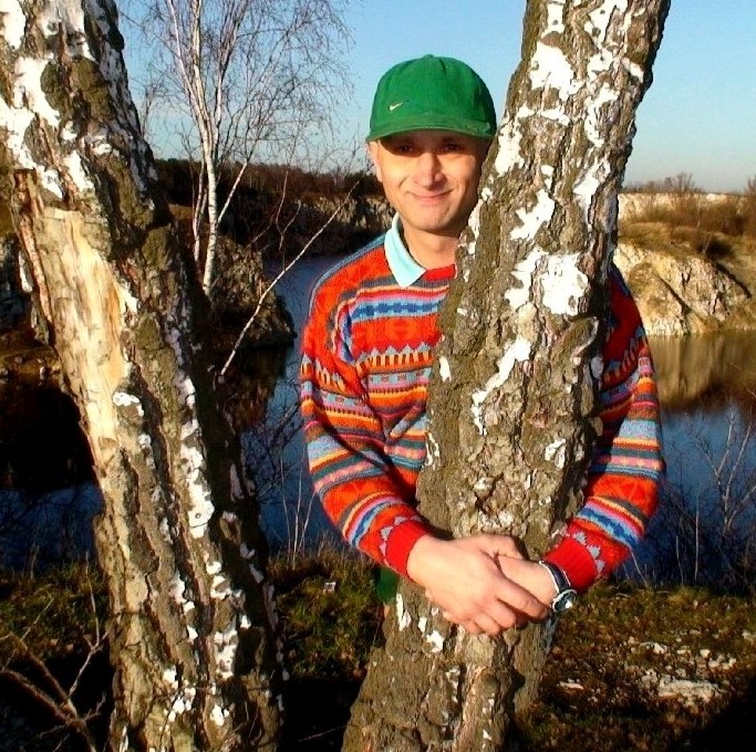 Samotny chłopak pod brzozą.